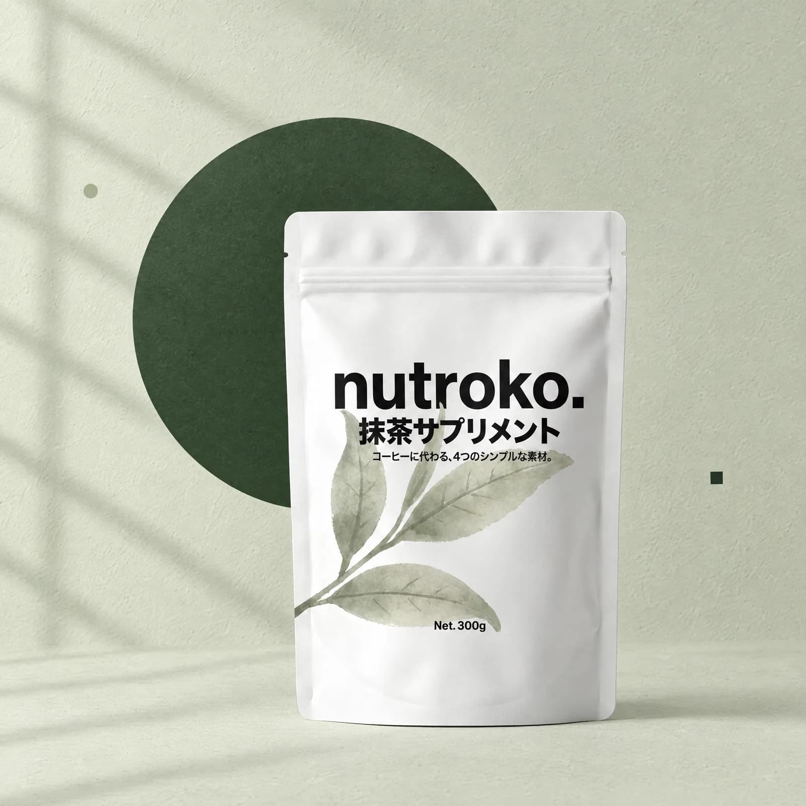 白いnutroko.のパウチ。淡いセージ色の壁と、深い抹茶色の丸い板の前に